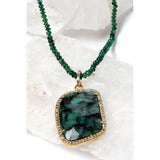 Close-up of the Emerald Wisdom necklace showcasing the statement emerald pendant, framed in a refined setting that enhances its depth, texture, and luminous character.