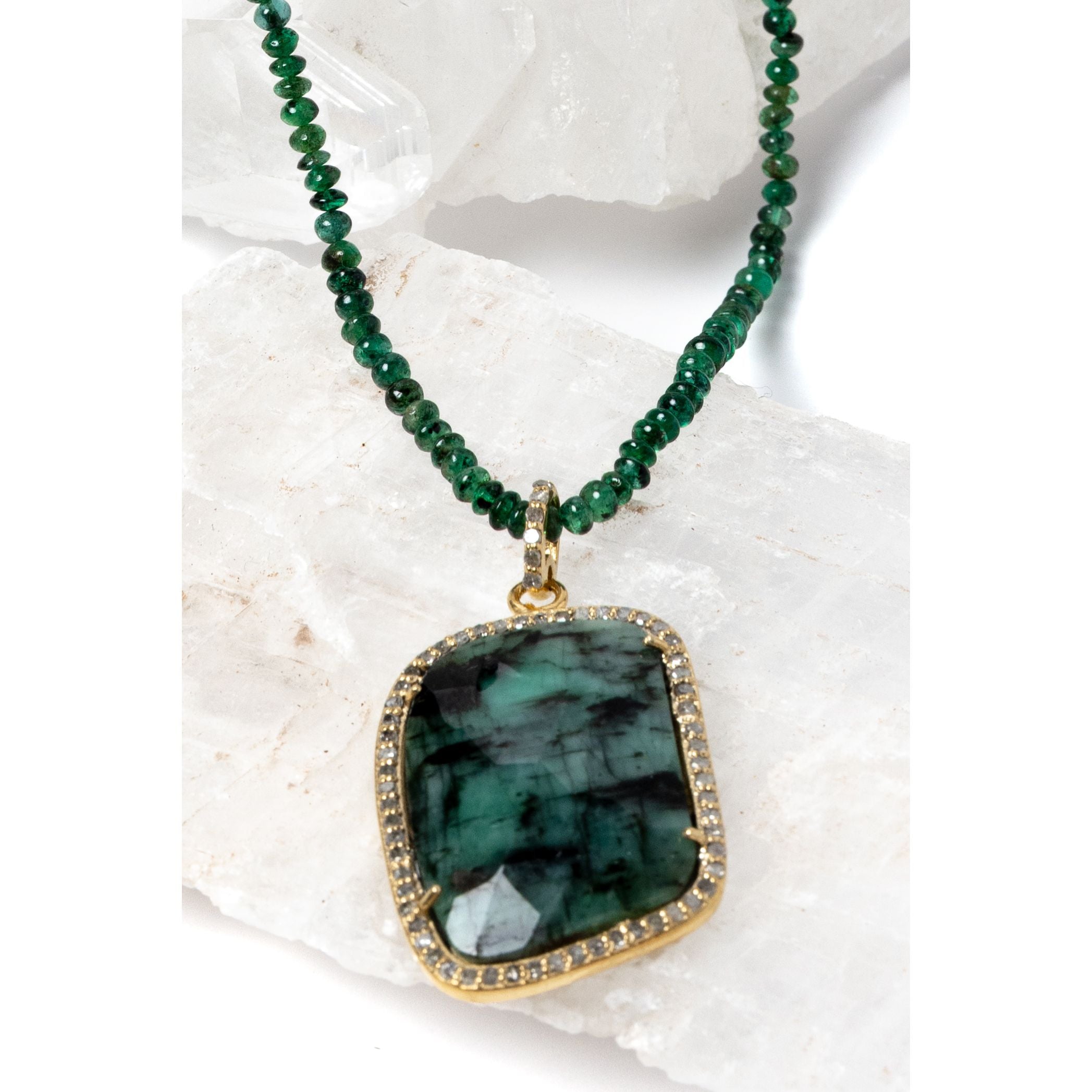 Close-up of the Emerald Wisdom necklace showcasing the statement emerald pendant, framed in a refined setting that enhances its depth, texture, and luminous character.