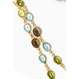 Close-up of the Rare Harmony necklace highlighting smoky quartz, blue topaz, and peridot gemstones in bezel settings along a fine gold chain, revealing the richness of color and refined craftsmanship.