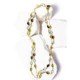 Rare Harmony gold station necklace featuring smoky quartz, blue topaz, and peridot gemstones arranged along a fine chain, creating a balanced, fluid composition of color and light.