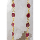 Close-up of the Cherry Bloom necklace highlighting cherry-colored rubies in bezel settings along a fine gold chain.