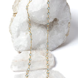 Delicate gold station necklace featuring beautiful blue topaz stones spaced along a fine chain, creating a fluid, light-catching rhythm.