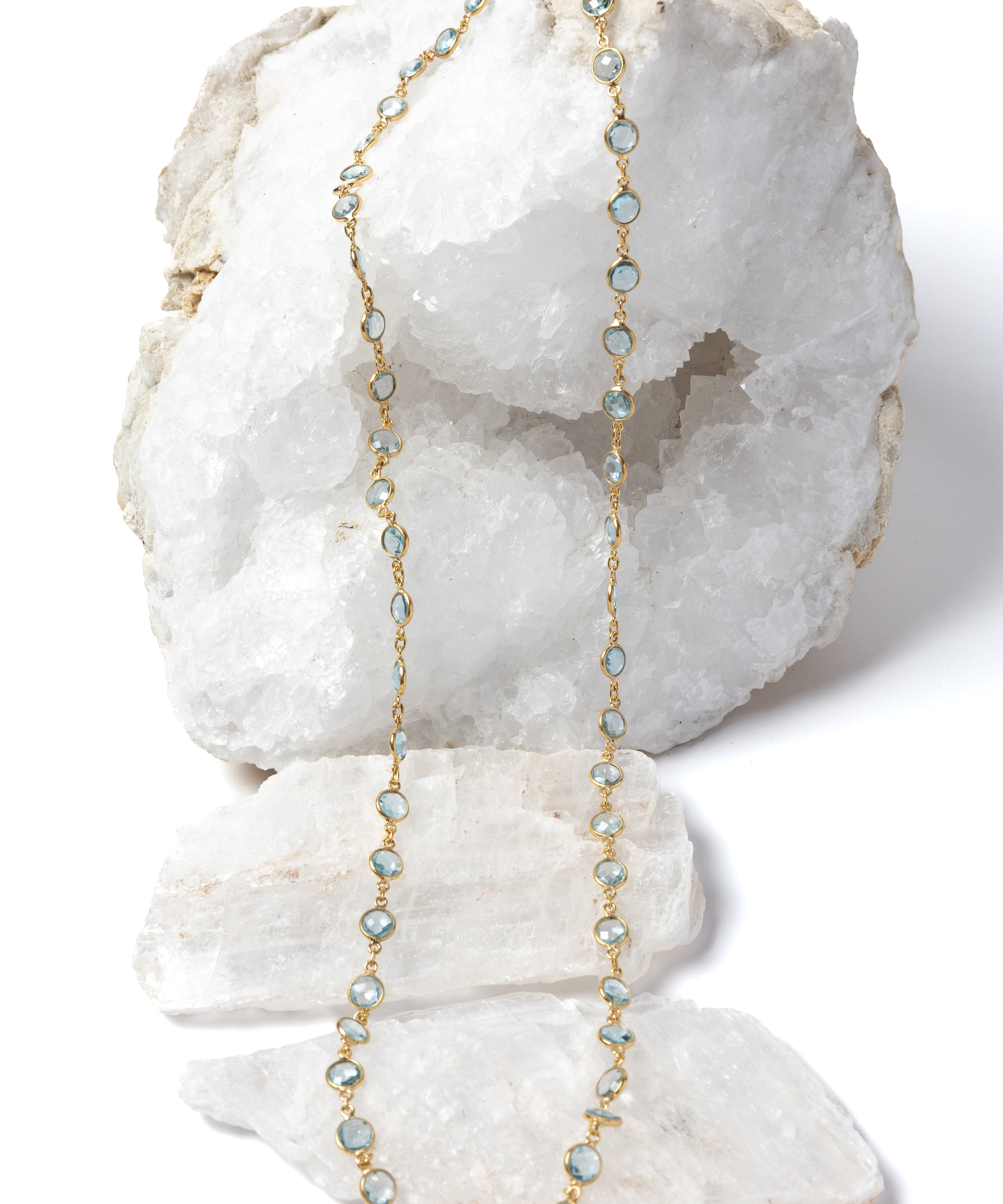 Delicate gold station necklace featuring beautiful blue topaz stones spaced along a fine chain, creating a fluid, light-catching rhythm.