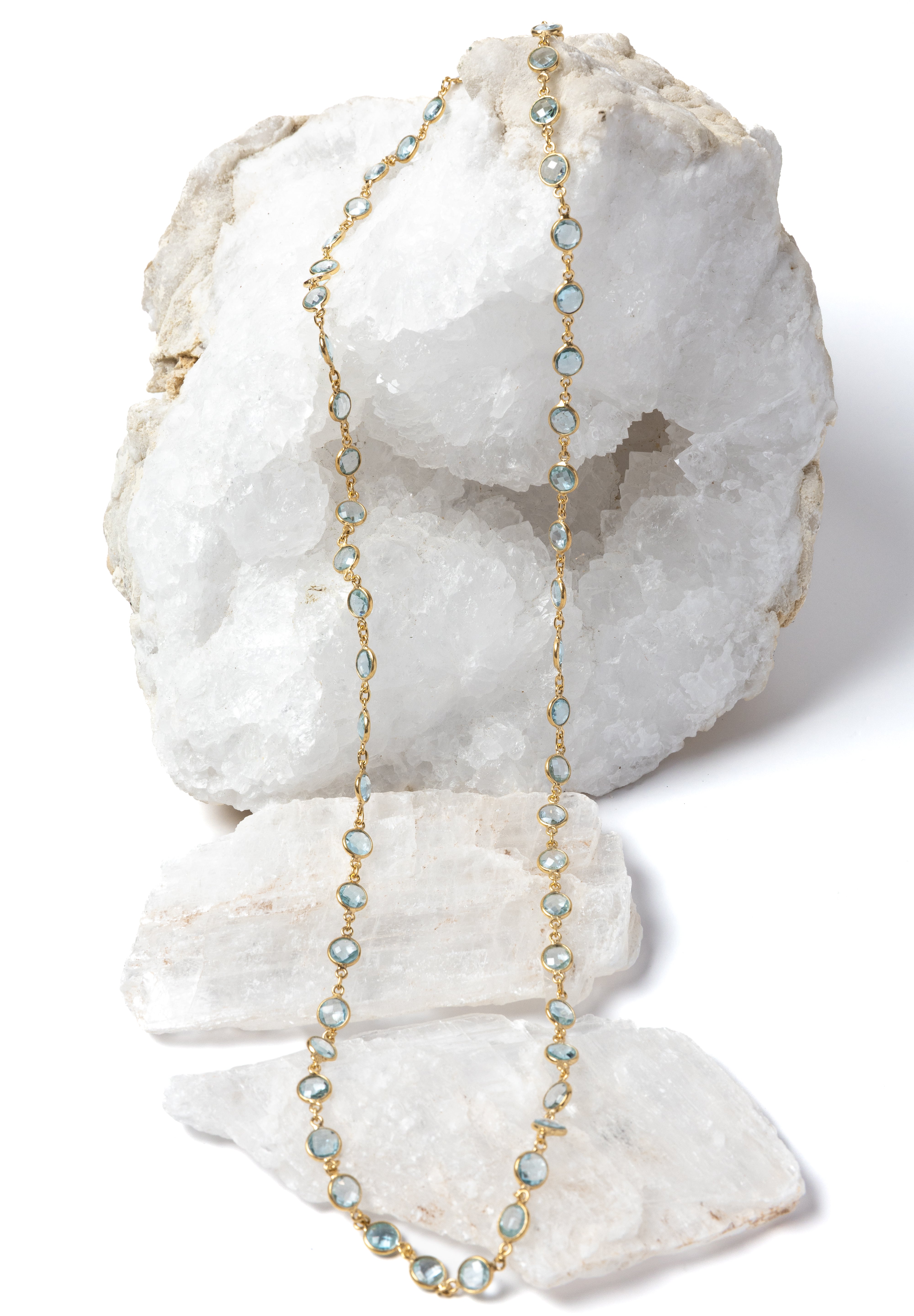 Delicate gold station necklace featuring beautiful blue topaz stones spaced along a fine chain, creating a fluid, light-catching rhythm.