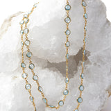 Soft Tide gold necklace featuring blue topaz stones, styled as a double-strand design to highlight its versatile wear.
