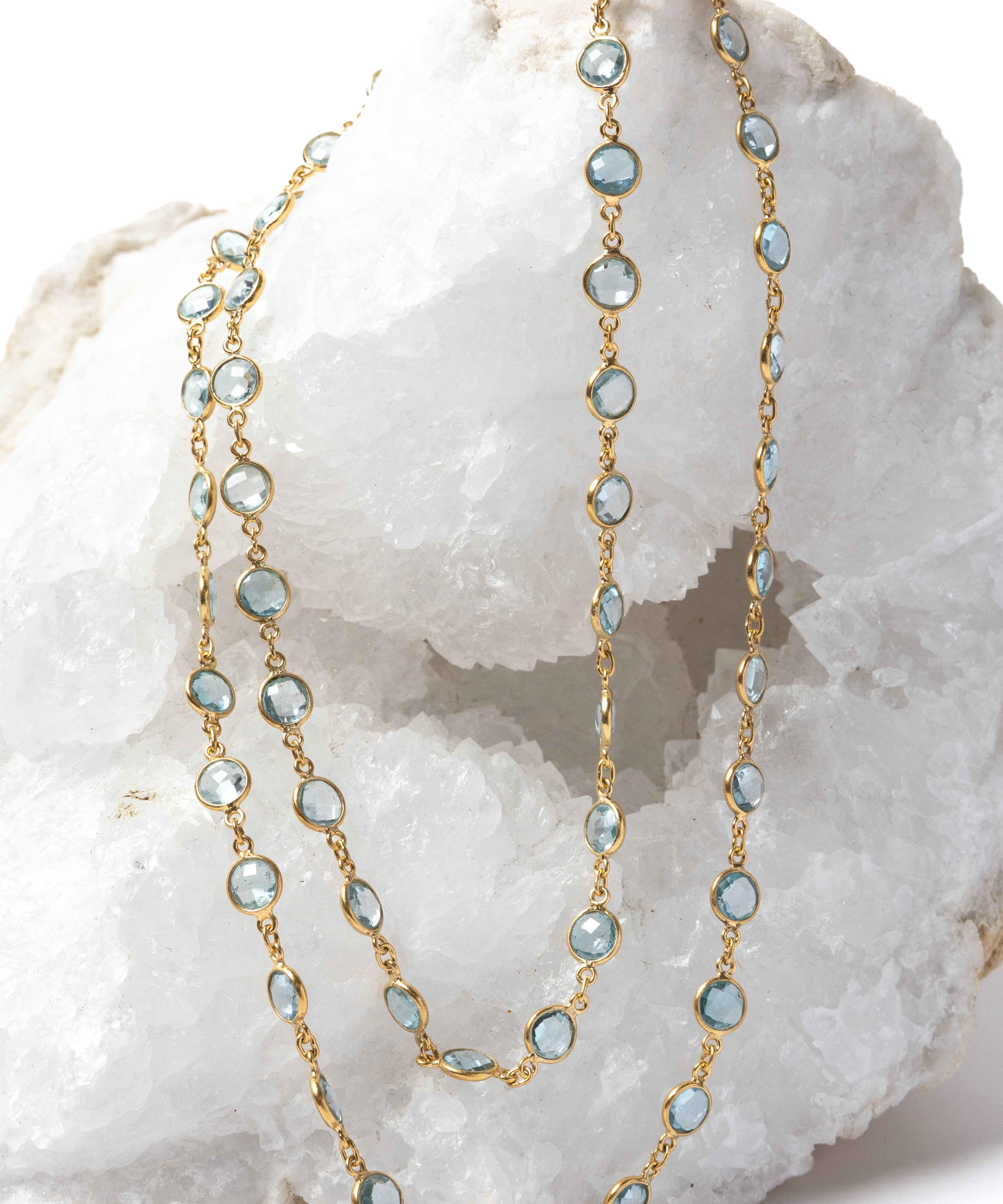 Soft Tide gold necklace featuring blue topaz stones, styled as a double-strand design to highlight its versatile wear.

