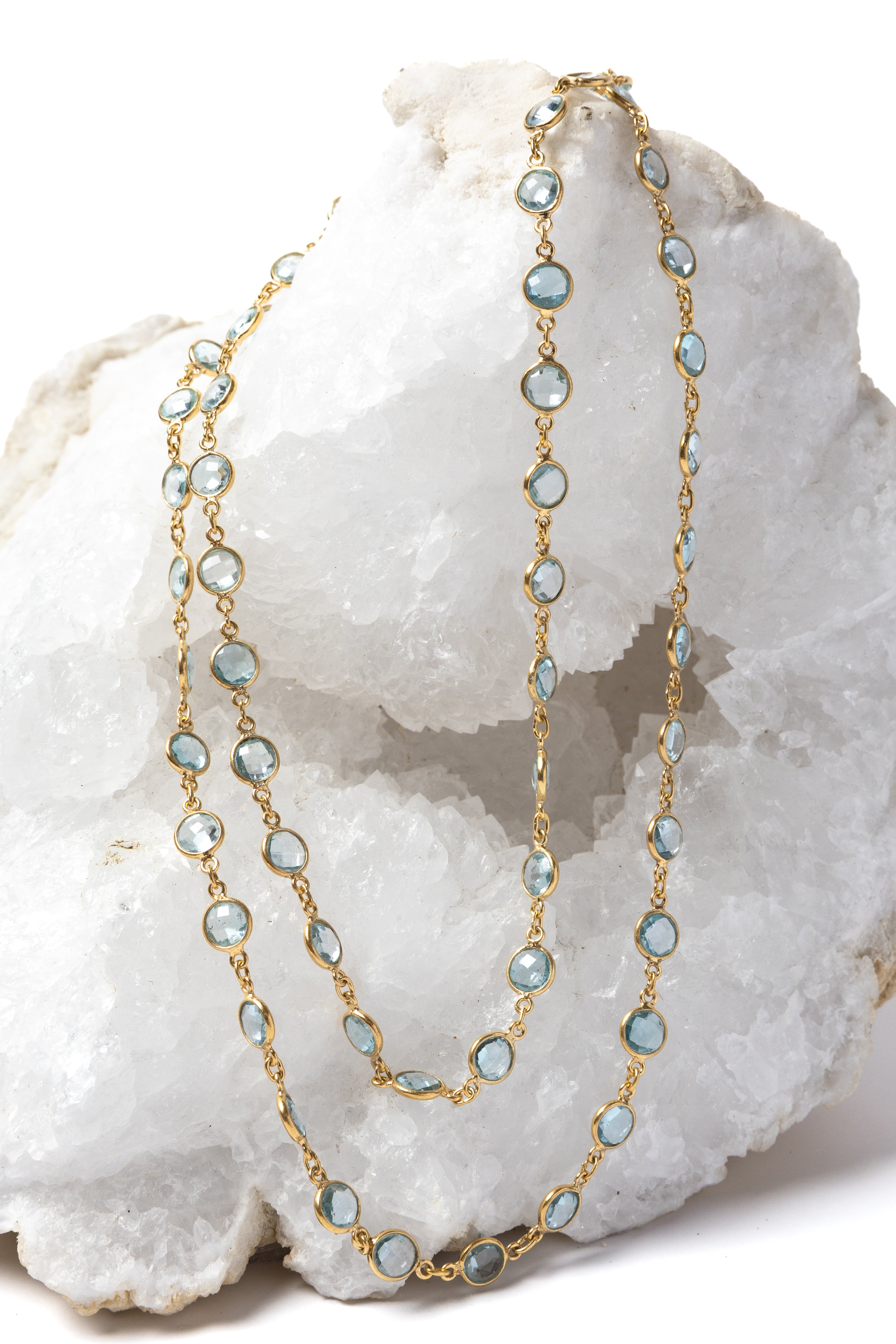 Soft Tide gold necklace featuring blue topaz stones, styled as a double-strand design to highlight its versatile wear.

