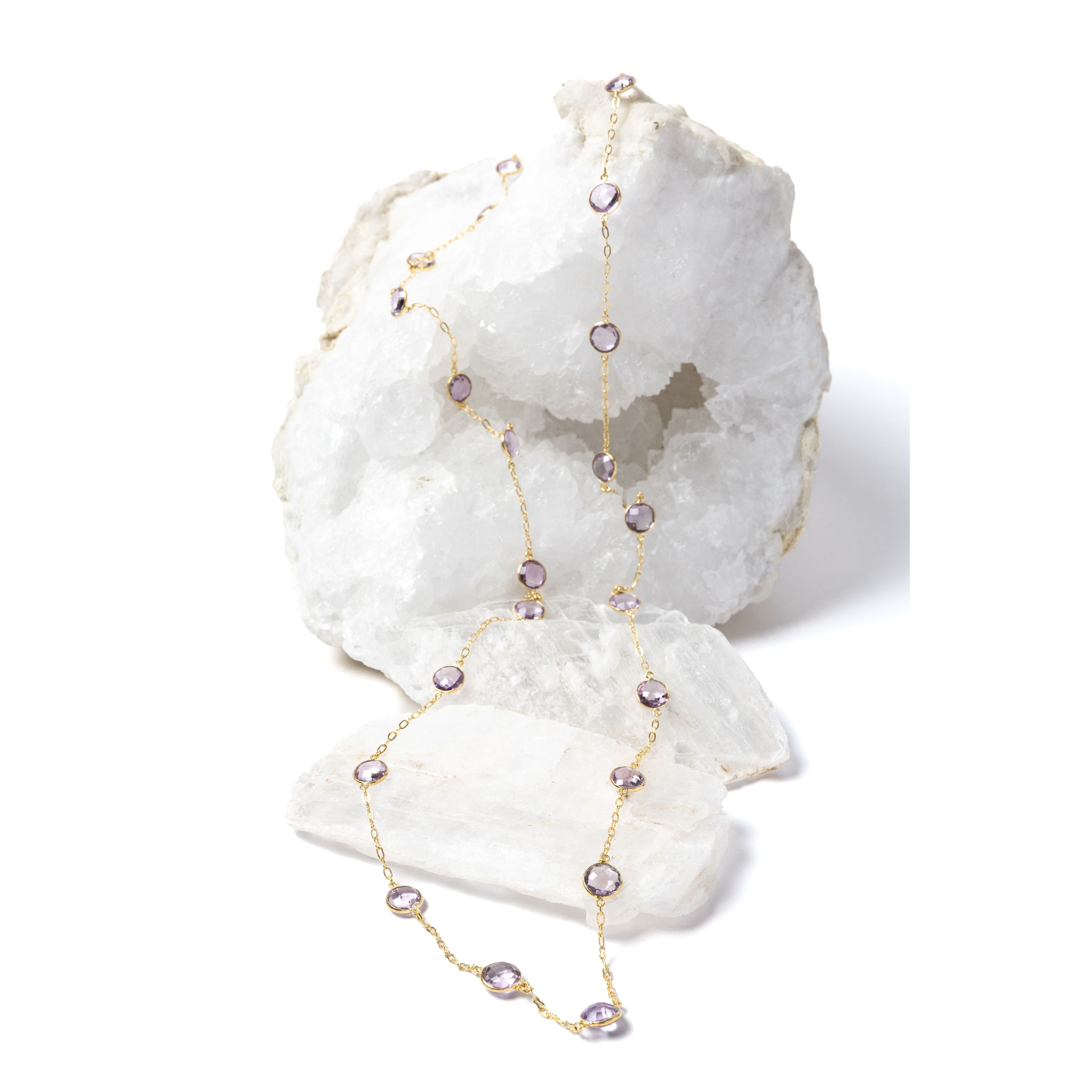 Delicate gold station necklace featuring clear, translucent lavender amethyst stones set along a fine chain, creating a soft, luminous rhythm.
