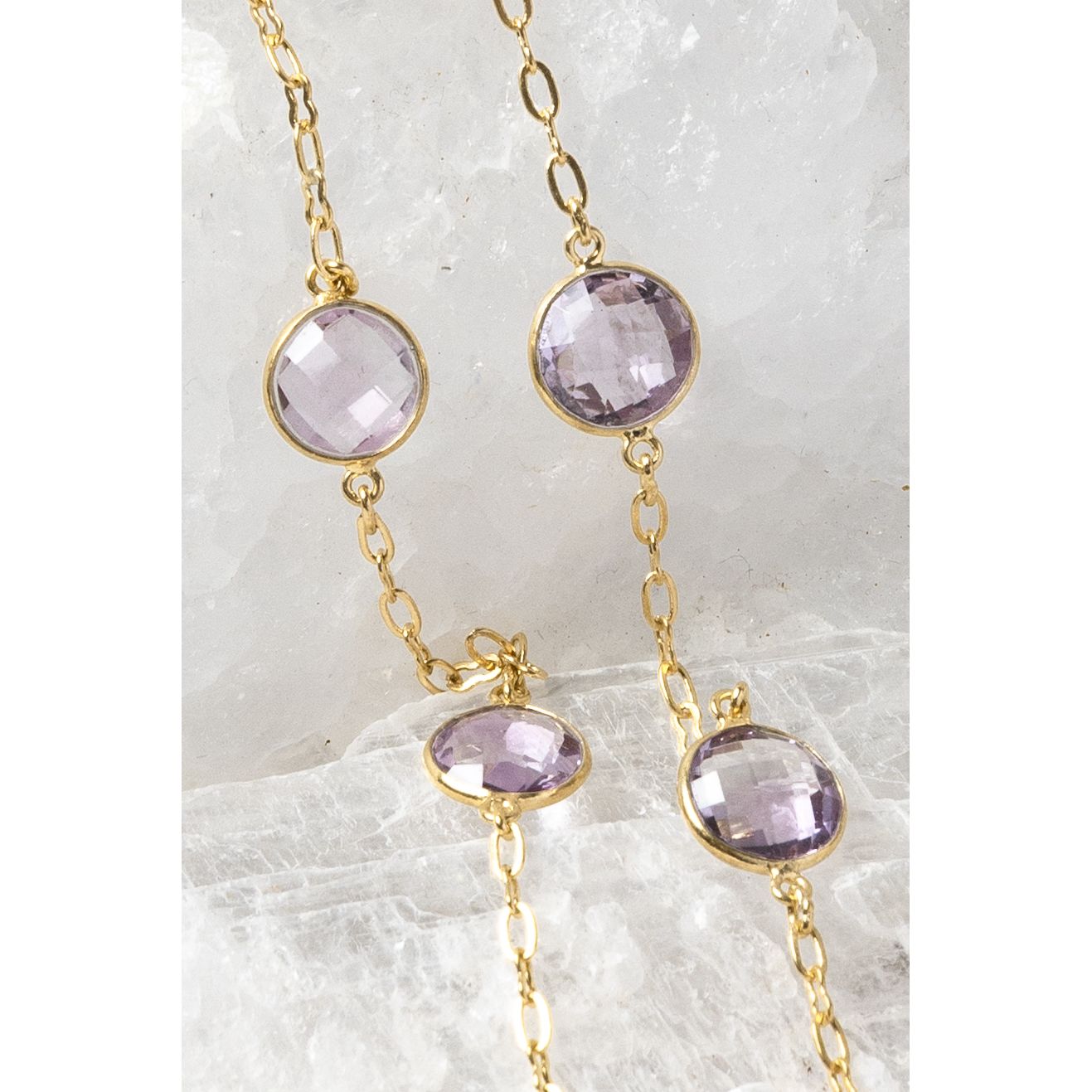 Close-up of the Violet Mist necklace highlighting clear, translucent lavender amethyst stones in bezel settings along a fine gold chain.