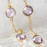 Close-up of the Violet Mist necklace highlighting clear, translucent lavender amethyst stones in bezel settings along a fine gold chain.