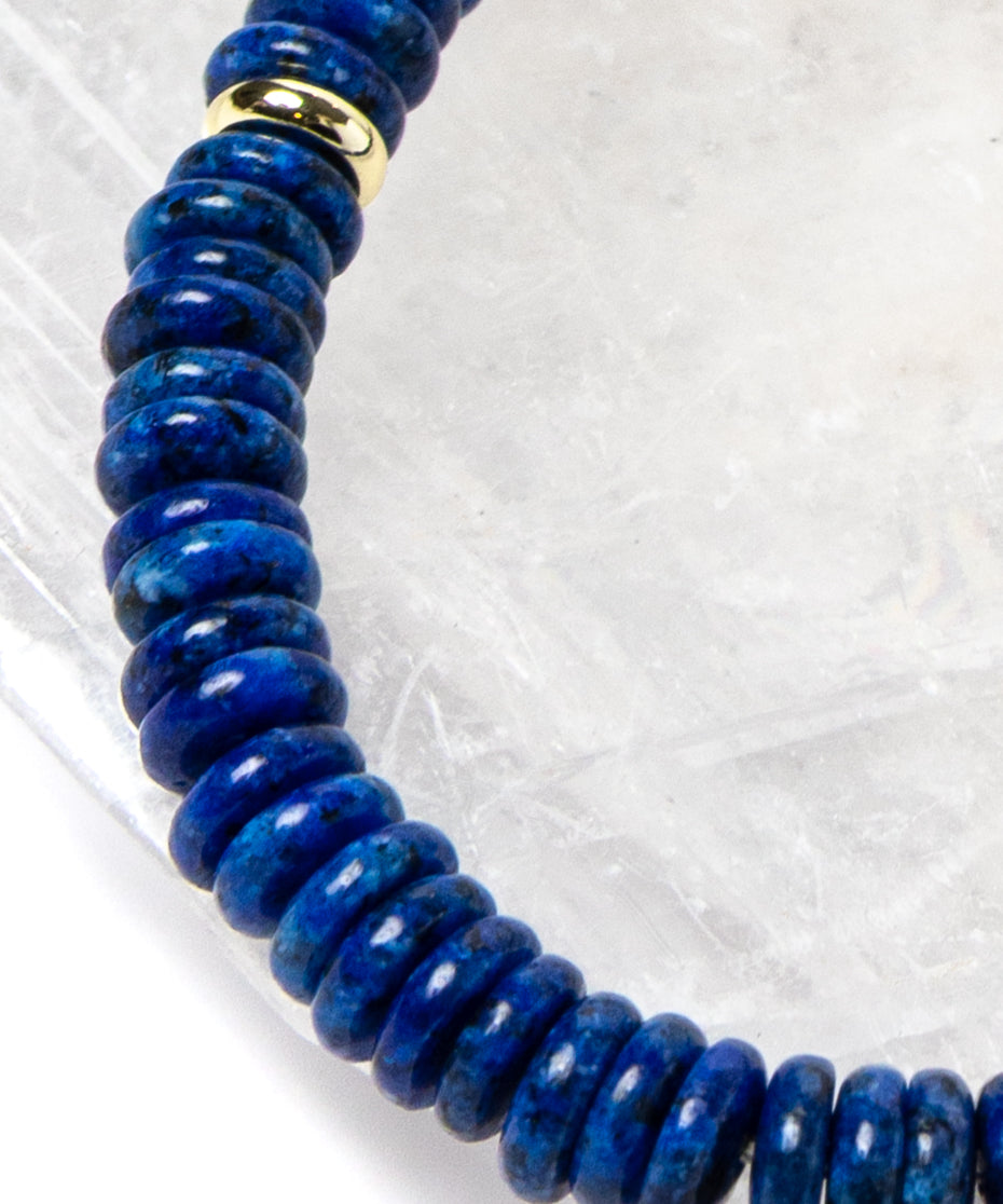 Close-up detail of rich midnight-blue lapis lazuli rondelles with polished gold-plated spacer accents highlighting the natural depth and velvety tone of the gemstones.