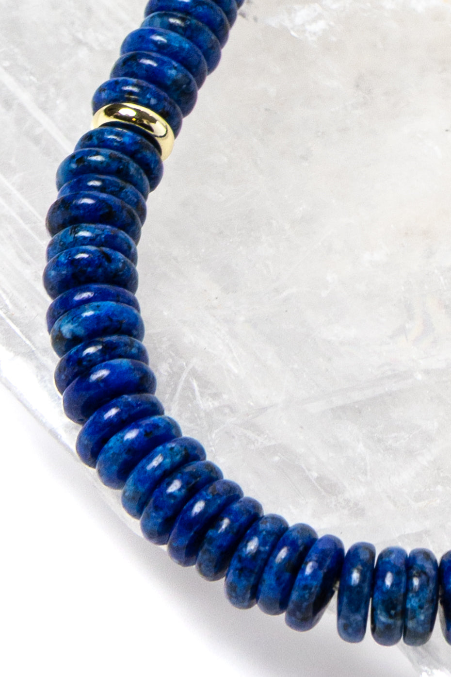 Close-up detail of rich midnight-blue lapis lazuli rondelles with polished gold-plated spacer accents highlighting the natural depth and velvety tone of the gemstones.