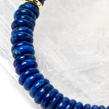 Close-up detail of rich midnight-blue lapis lazuli rondelles with polished gold-plated spacer accents highlighting the natural depth and velvety tone of the gemstones.