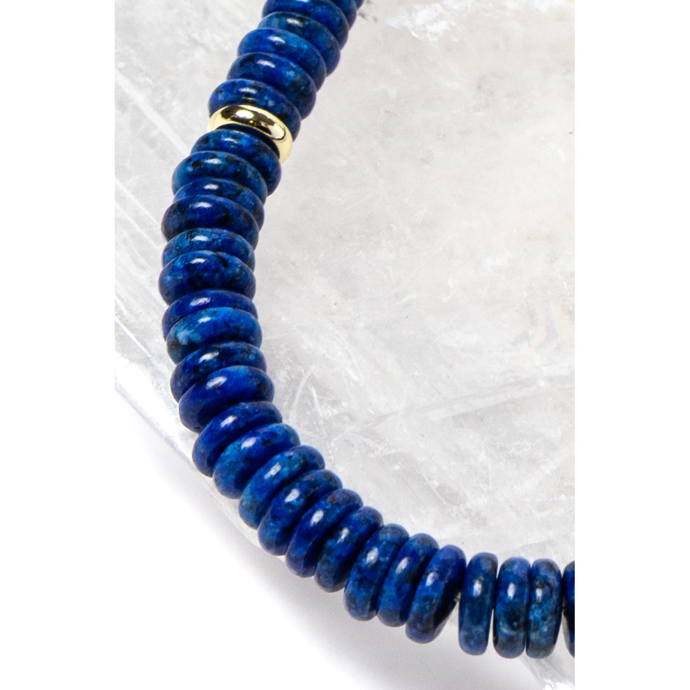 Close-up detail of rich midnight-blue lapis lazuli rondelles with polished gold-plated spacer accents highlighting the natural depth and velvety tone of the gemstones.