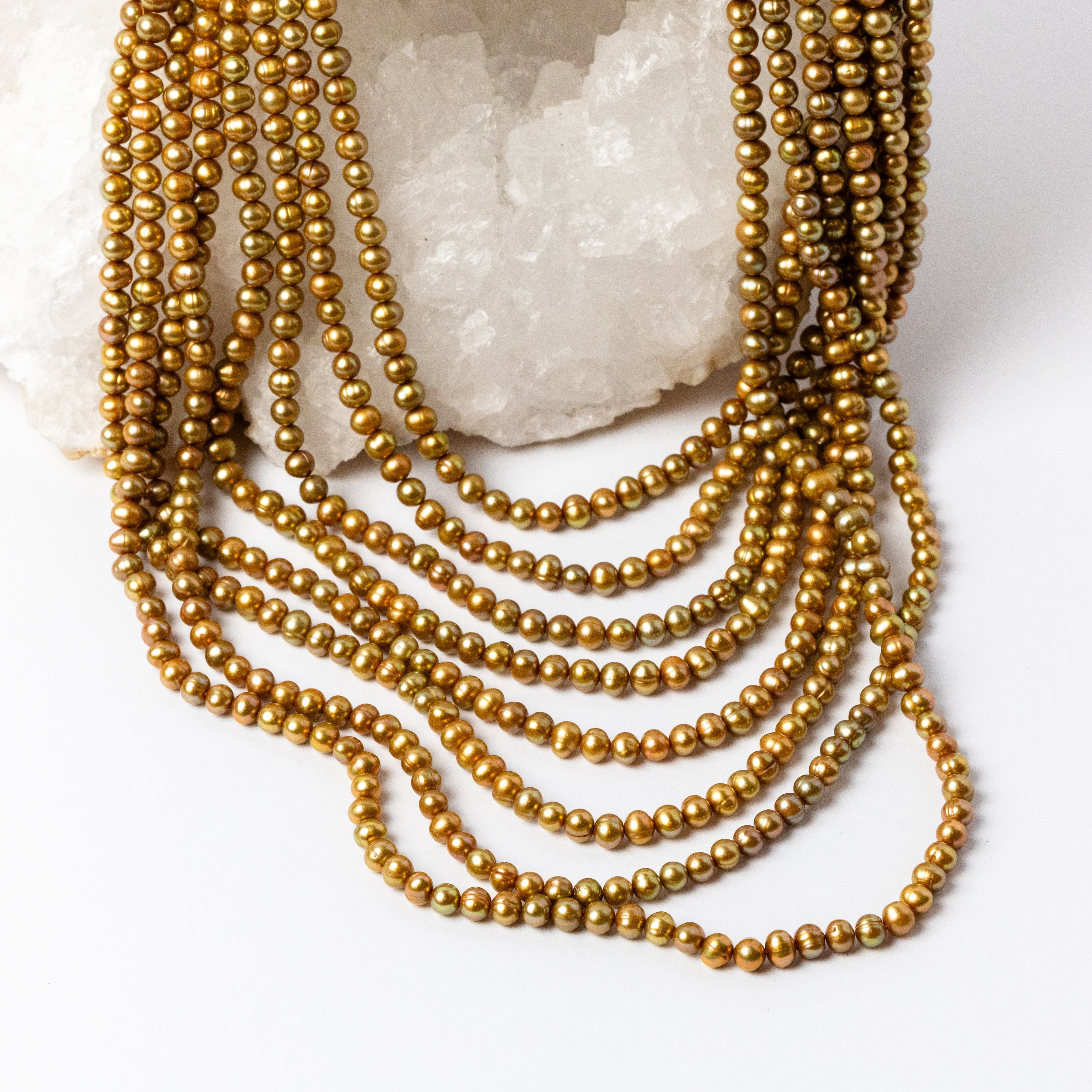 Close-up of Pearl Opulence Necklace highlighting the natural luster, rich honey-gold and champagne tones, subtle olive-green undertones, and organic shapes of the approximately 6–7 mm freshwater potato pearls.