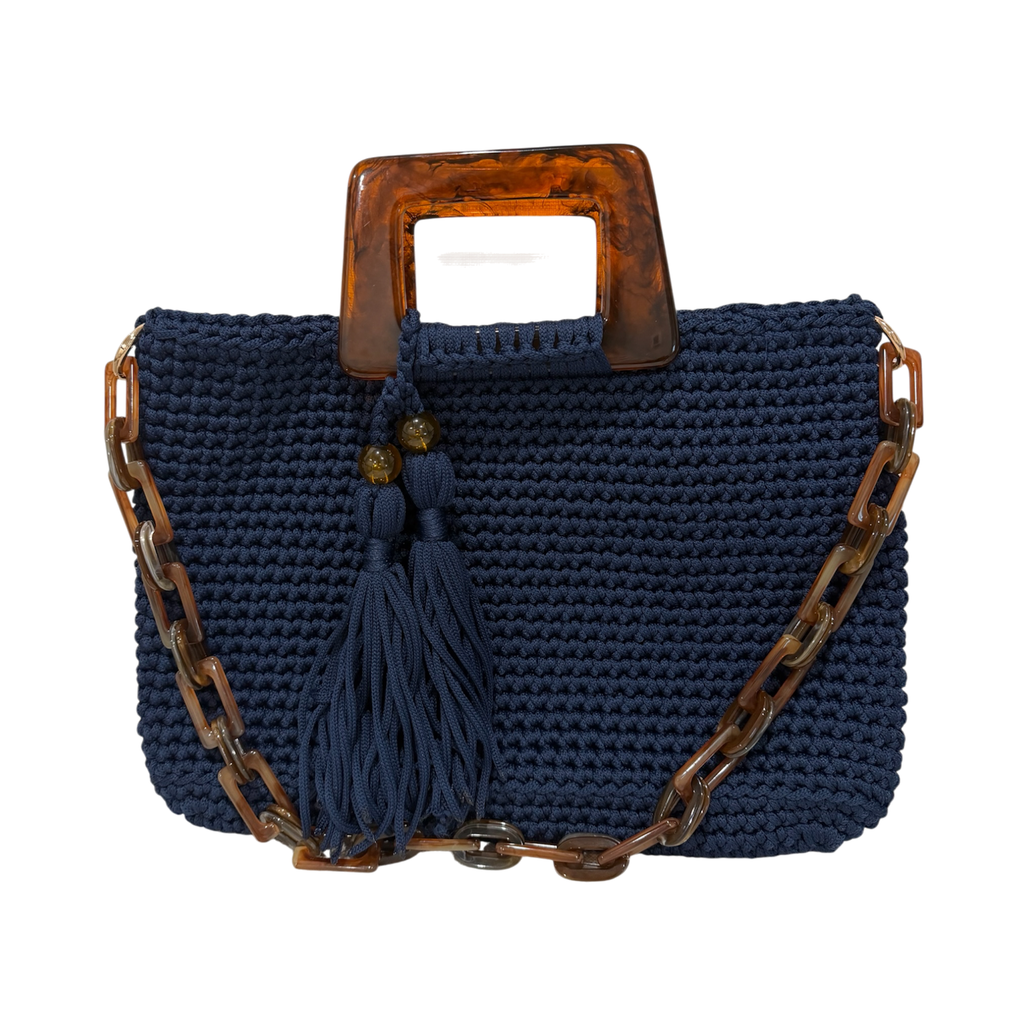 Hand-crocheted Monique handbag in deep navy blue with a warm marbled resin top handle, coordinating resin chain strap, and double tassel detail.