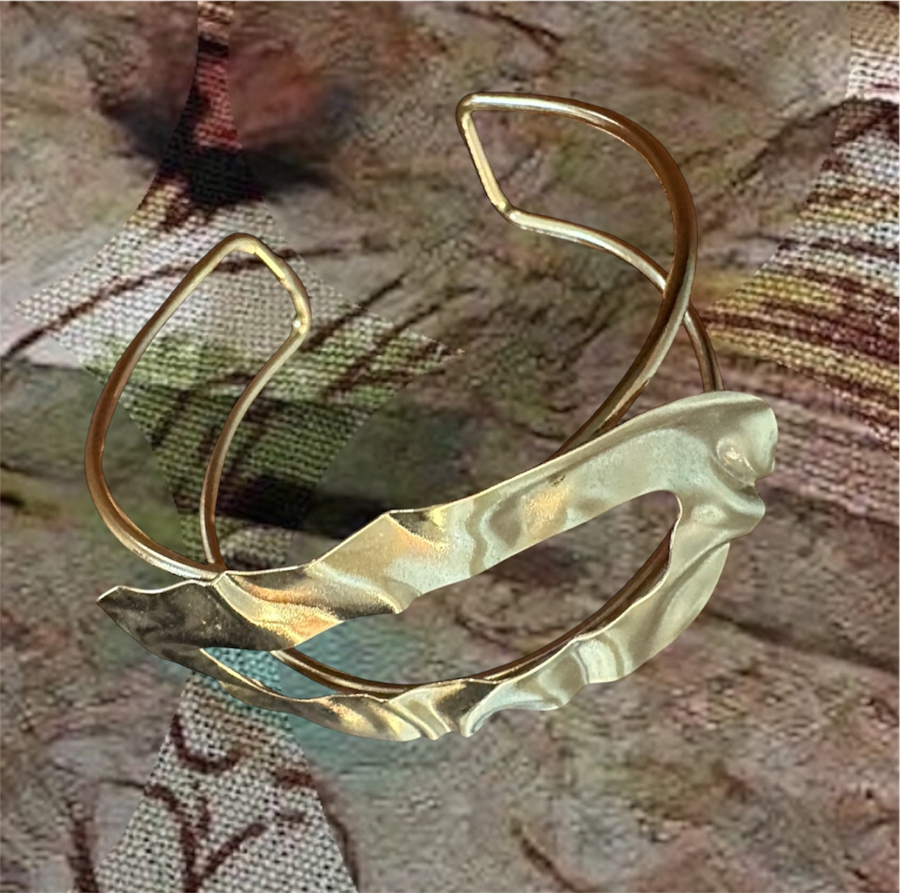 Gold-plated sculptural cuff bracelet with fluid wavy form and textured finish