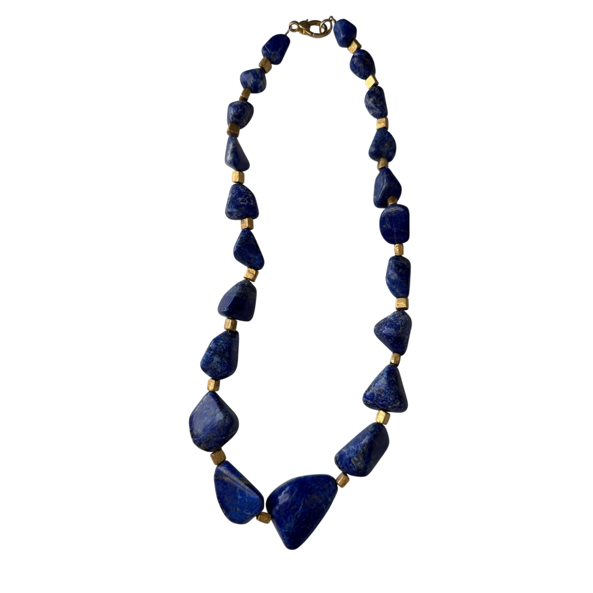 One-of-a-kind lapis stone necklace featuring organically shaped cobalt-blue gemstones separated by gold-plated spacers in a sculptural statement design.