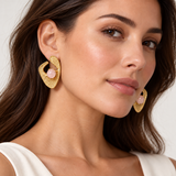 Model wearing two-inch sculptural yellow-gold earrings with 12 mm round rose quartz cabochons.