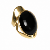 Allure statement ring featuring a natural 25 × 18 mm black onyx cabochon in a sculptural gold-plated setting with an ergonomic, comfortable design.
