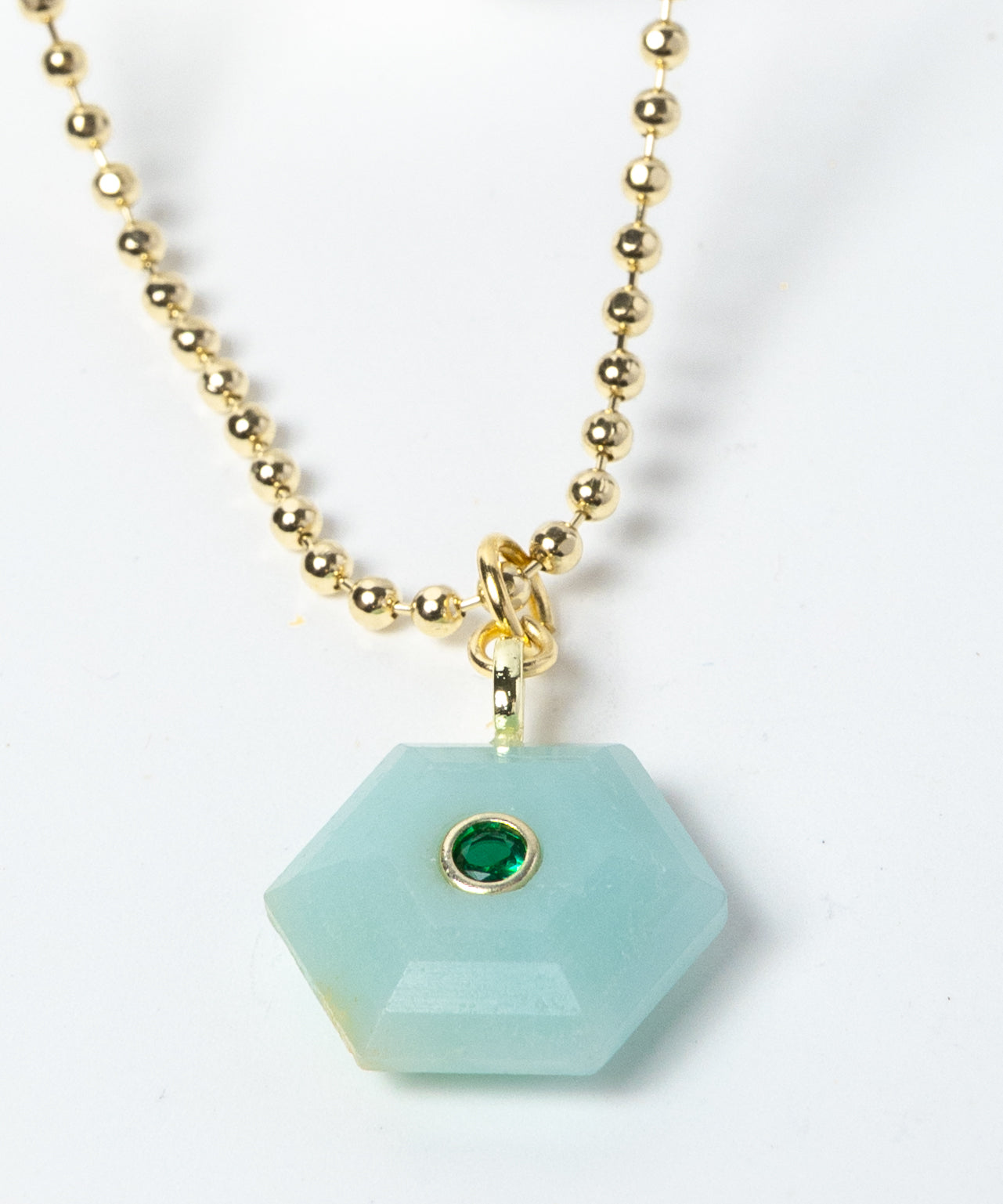 Close-up of a natural Amazonite pendant showcasing serene aqua-blue tones, faceted geometric shape, green cubic zirconia detail, and gold-plated setting.