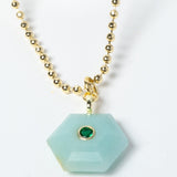 Close-up of a natural Amazonite pendant showcasing serene aqua-blue tones, faceted geometric shape, green cubic zirconia detail, and gold-plated setting.