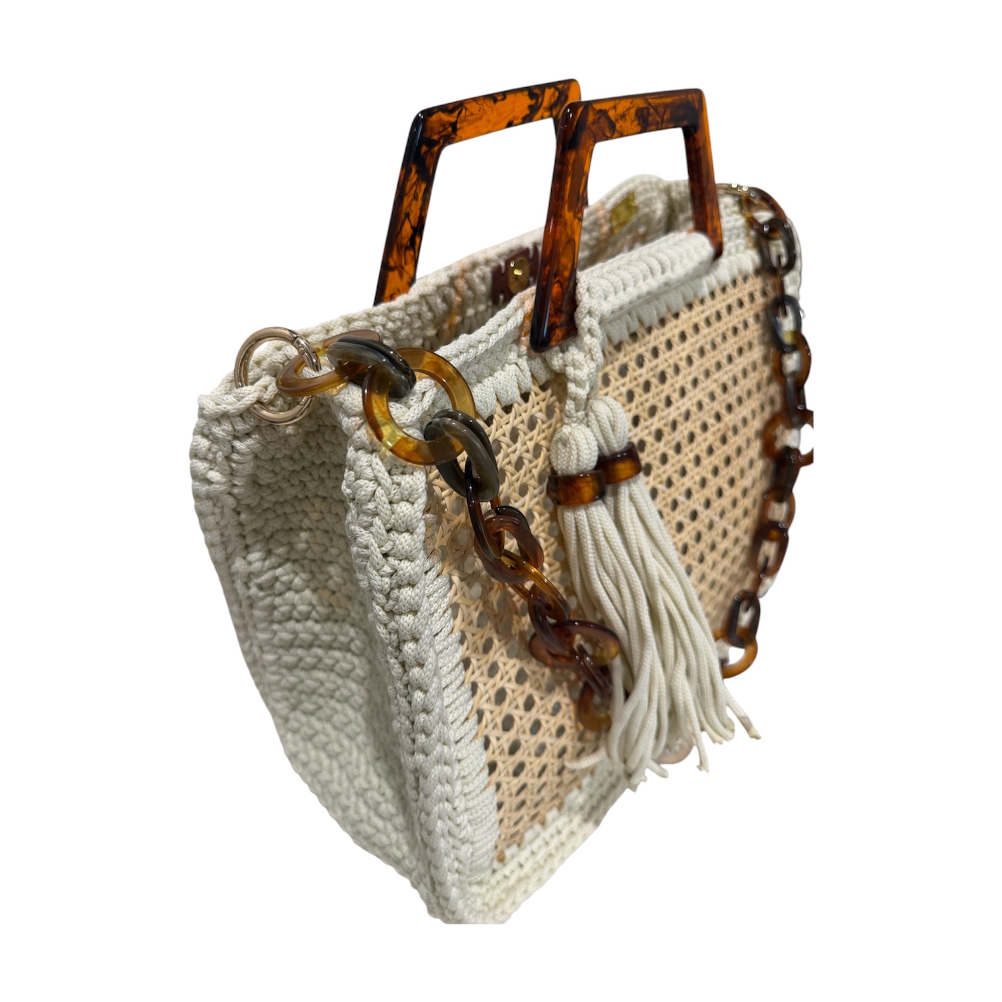 Side view of the Amélie · Coastal Breeze handbag featuring an architectural woven rattan body framed by richly textured off-white crochet, sculptural marbled resin handles, statement resin chain strap, elongated tassel detail, and dimensional handcrafted construction with an airy open silhouette.