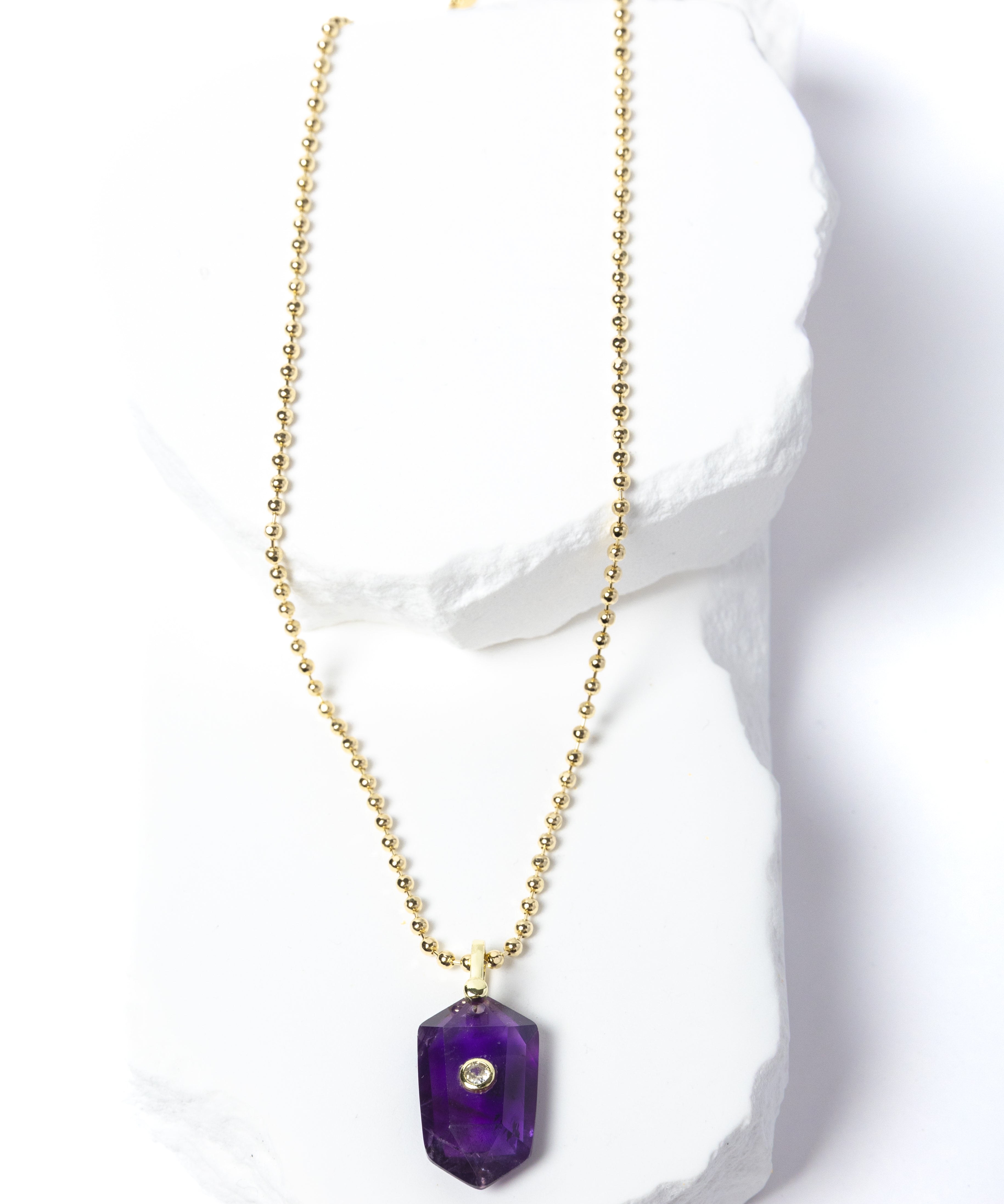 Natural Amethyst Gem Charm Necklace featuring a faceted violet-purple gemstone pendant with a cubic zirconia accent suspended from a gold-plated beaded chain