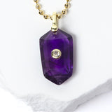 Close-up of a natural Amethyst pendant showcasing rich violet-purple tones, faceted geometric shape, cubic zirconia detail, and gold-plated setting.
