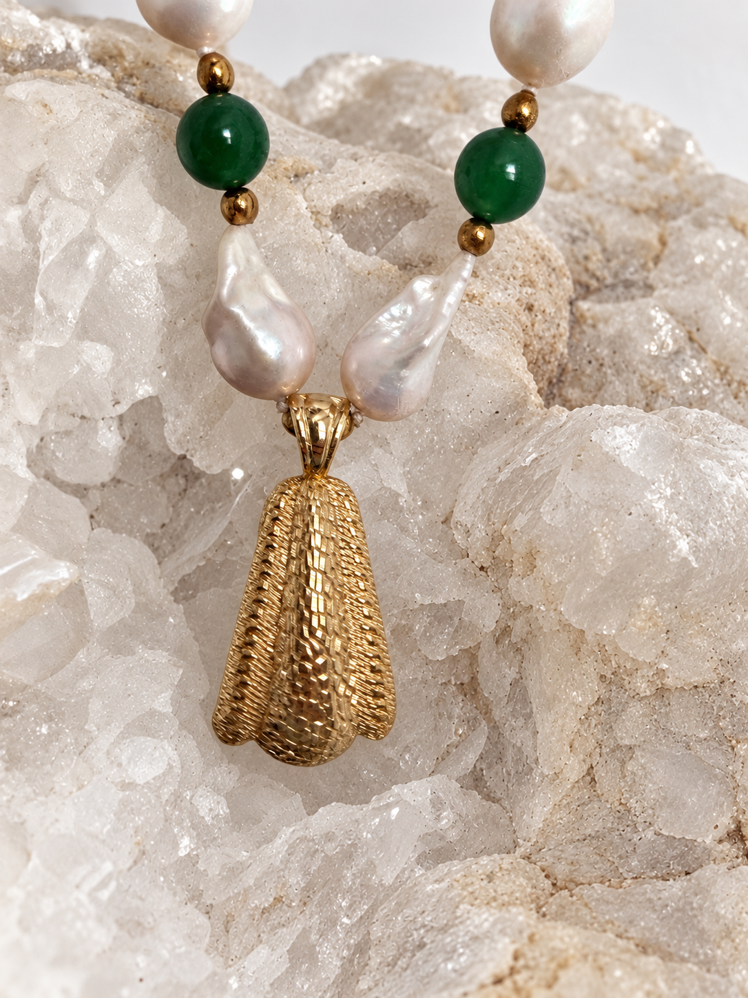 Reverse view of the necklace pendant showing its textured gold-tone surface, designed to be worn facing either direction.