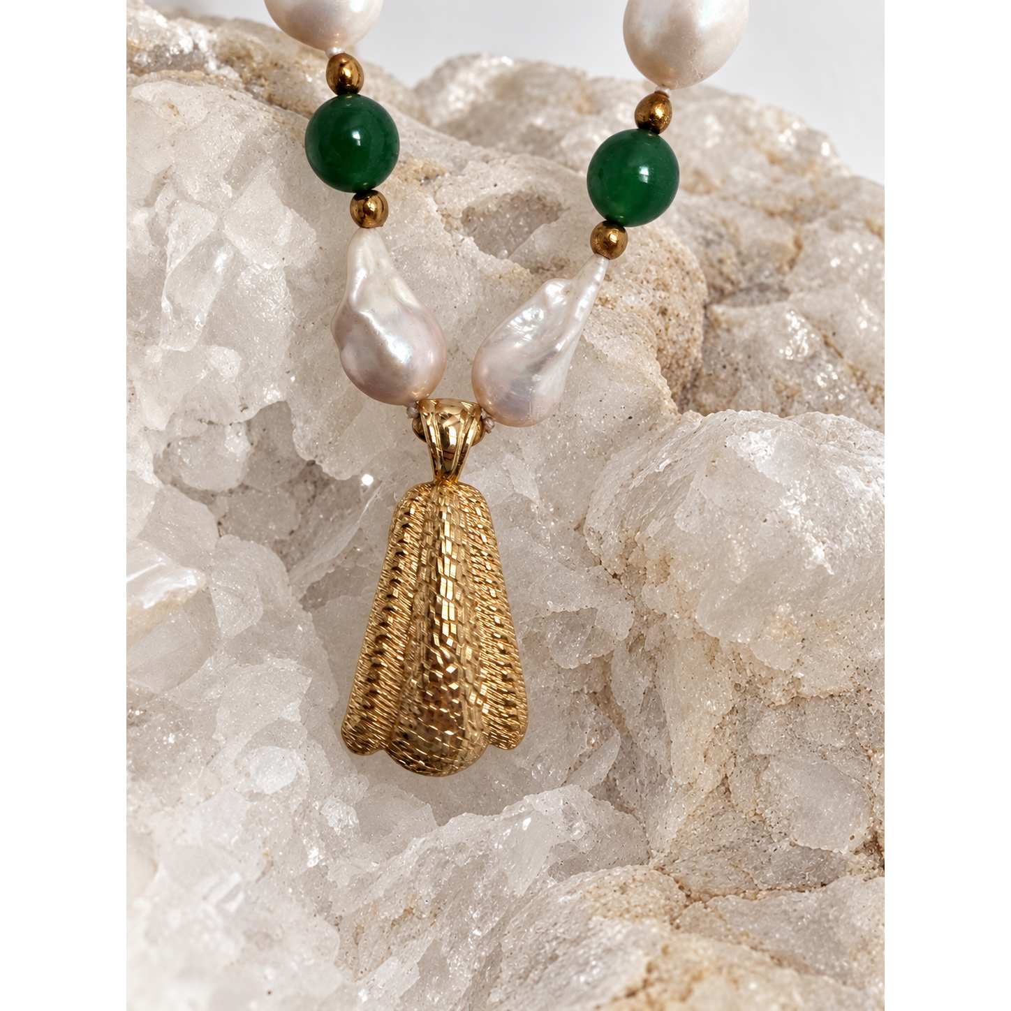 Reverse view of the necklace pendant showing its textured gold-tone surface, designed to be worn facing either direction.