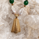 Reverse view of the necklace pendant showing its textured gold-tone surface, designed to be worn facing either direction.