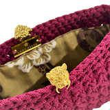 Interior of the Bertha Clutch Berry Epoch featuring a gold-tone tiger clasp, botanical lining, magnetic closure, and hand-crocheted construction.