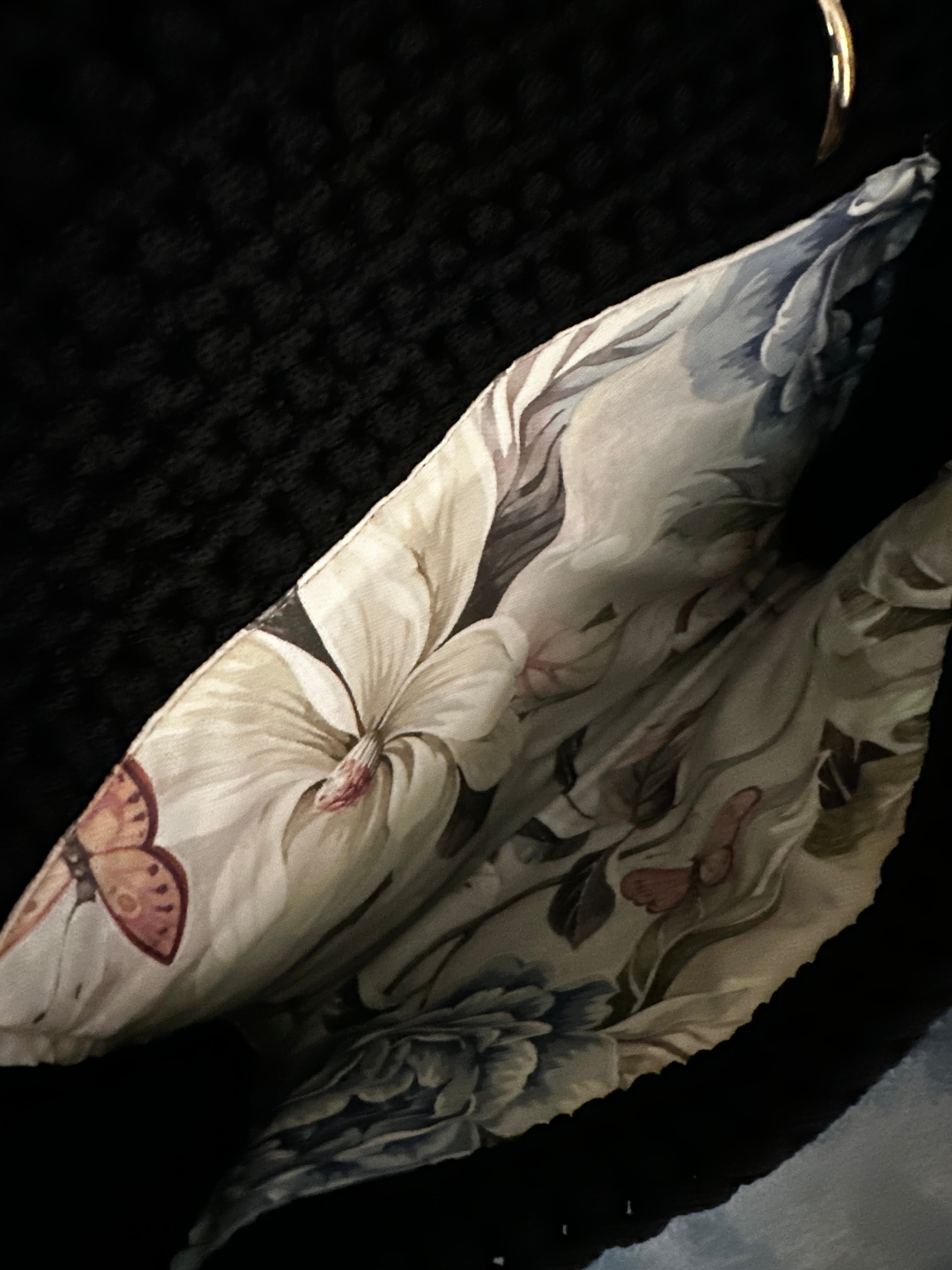 Interior of the Camille clutch revealing a softly structured silhouette lined in an elegant floral textile with delicate butterfly accents, echoing the Butterfly Island motif.