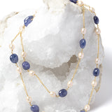 Blue Waltz necklace styled as a two-strand silhouette, showcasing rich blue tanzanites, luminous freshwater pearls, and a gold-plated chain.