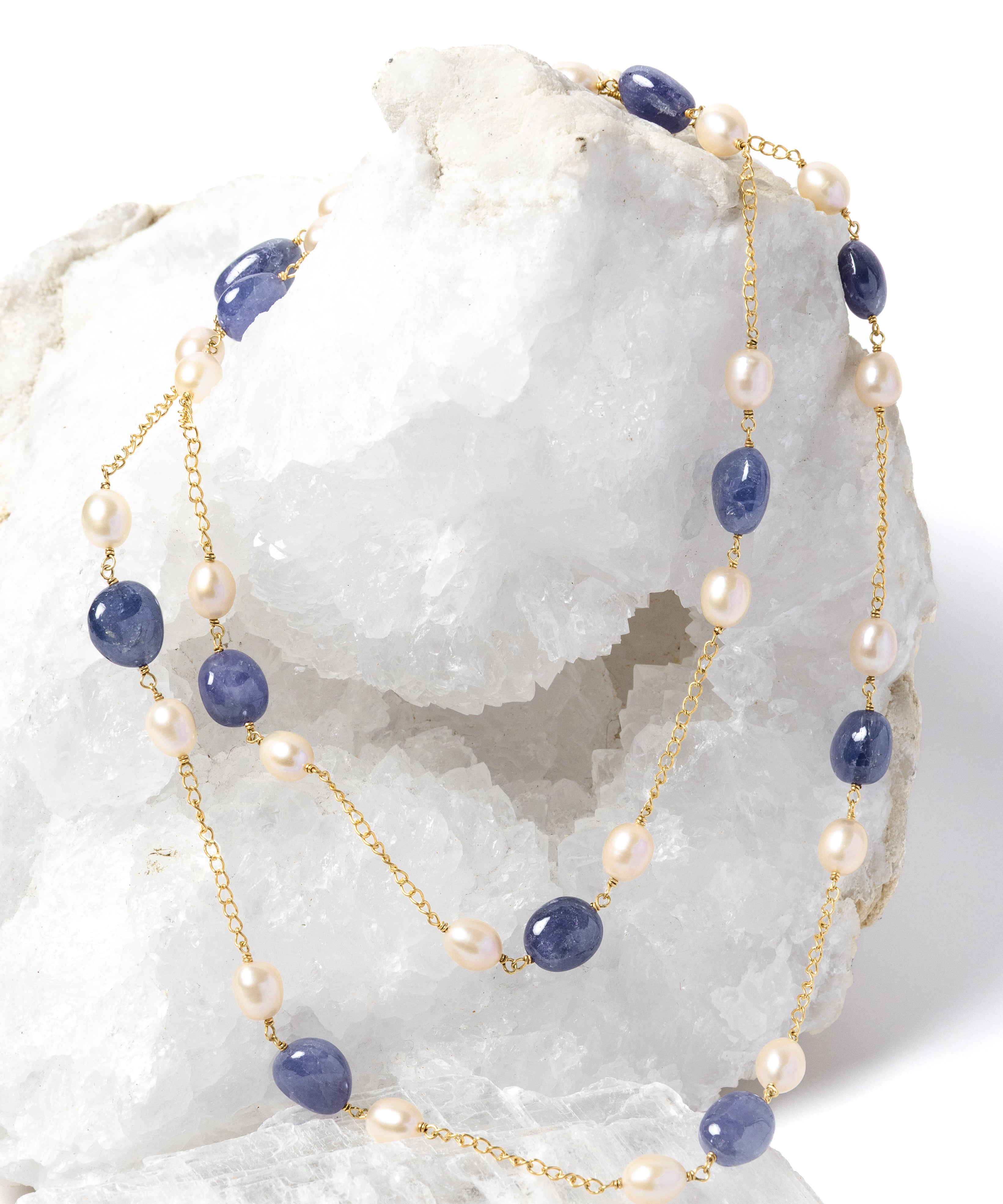 Blue Waltz necklace styled as a two-strand silhouette, showcasing rich blue tanzanites, luminous freshwater pearls, and a gold-plated chain.