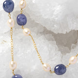 Close-up of Blue Waltz highlighting natural tanzanite gemstones, softly lustrous freshwater pearls, and gold-plated chain details.