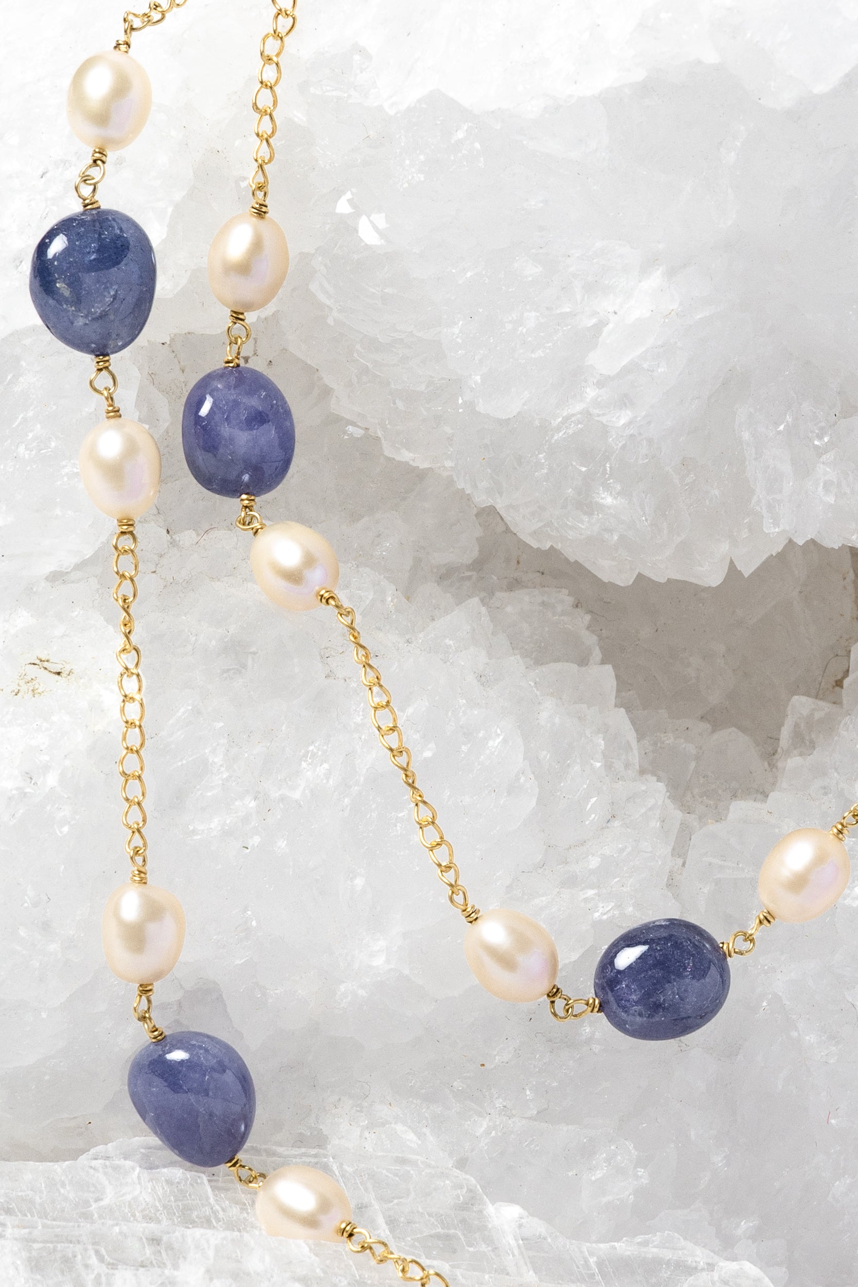 Close-up of Blue Waltz highlighting natural tanzanite gemstones, softly lustrous freshwater pearls, and gold-plated chain details.