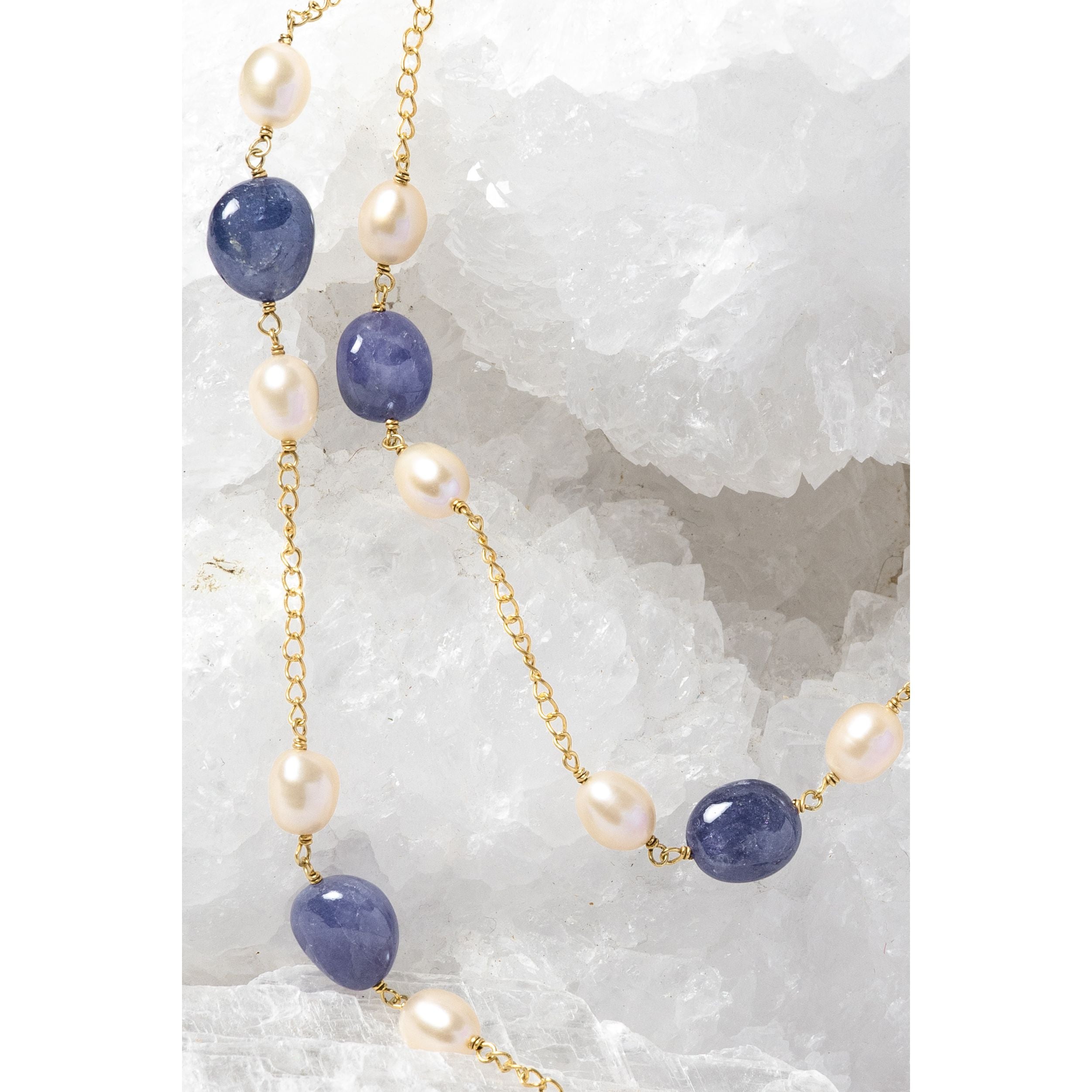 Close-up of Blue Waltz highlighting natural tanzanite gemstones, softly lustrous freshwater pearls, and gold-plated chain details.