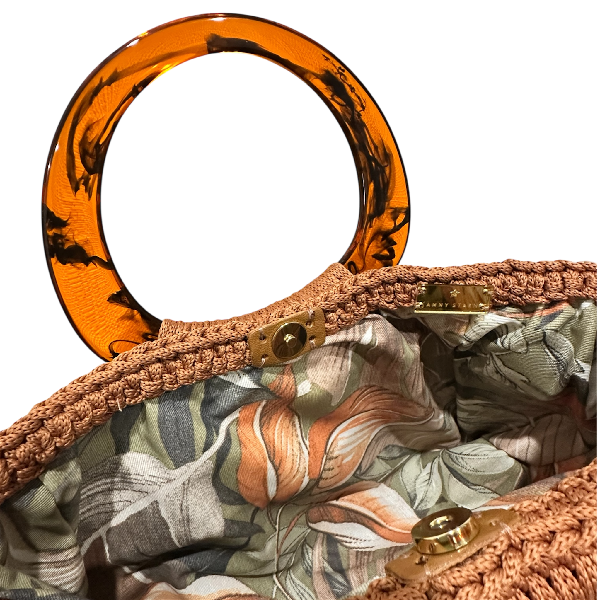Hand-crocheted luxury handbag interior with botanical lining and spacious open design, featuring intricate crochet texture, sculptural resin handle and flowing tassel with chain detail
