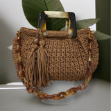 
Hand-crocheted Giselle handbag in a warm cognac tone with dimensional vertical textured stitching, featuring marbled amber resin round handles and a coordinating chain strap.
