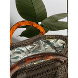 Interior view of the Paloma handbag · Wood & Water, featuring a bold botanical leaf lining in soft green and neutral tones, framed by the structured crochet body and finished with refined resin handle details.