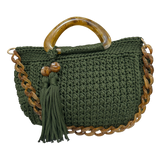 Hand-crocheted Giselle handbag in a deep moss green tone with dimensional textured stitching, featuring marbled resin round handles, a coordinating chain strap, and tassel accents with polished bead details.
