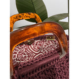 Interior view of the Giselle handbag · Bordeaux Luxe, featuring an ornamental scroll-pattern lining in bordeaux and soft ivory tones, framed by the structured crochet body and finished with polished resin handle details.