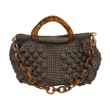 Hand-crocheted Paloma handbag in warm earth tones with dimensional texture, featuring sculptural amber-marbled resin handles and a coordinating resin chain strap.