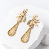 Side view of Fleur de Lumière earrings showing the dimensional floral design and delicate, elongated hand-woven teardrops with intricate openwork detailing.