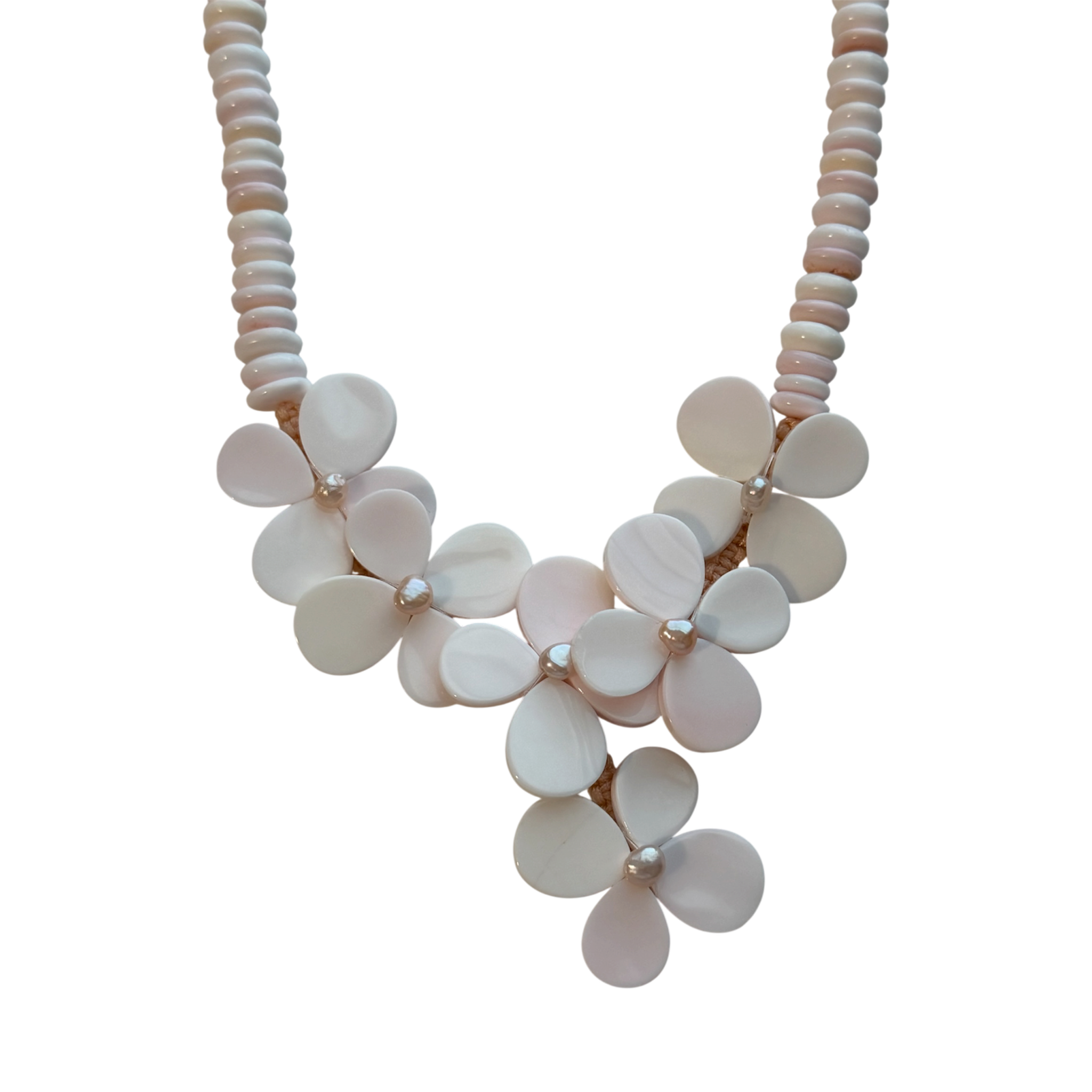 Close-up of the Flor del Mar necklace showcasing handcrafted floral motifs created from natural blush conch shell with freshwater pearl accents.