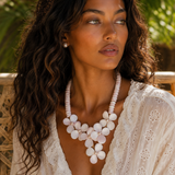 Model wearing the Flor del Mar conch shell and freshwater pearl necklace, showcasing its sculptural floral design and elegant statement silhouette.