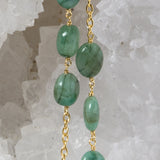 Close-up of the Fortuna Necklace highlighting natural emerald gemstones with rich creamy green tones, a distinctive velvety character, and gold-plated chain details.