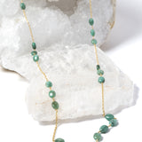 Fortuna Necklace featuring natural emerald gemestones set along a gold-plated chain, a graceful long necklace with a beautifully balanced center composition.
